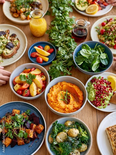 Table full of different types of food and drinks. there are multiple plates and bowls of food arranged in an aesthetically pleasing manner.