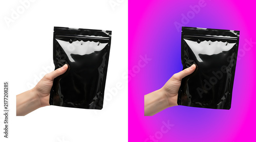 Foto A hand holding a medium sized black plastic zipper pouch, isolated on a white ba