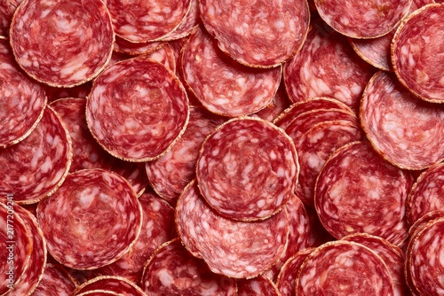 Salami slices arranged in a neat pattern on a table for display or sale at a market