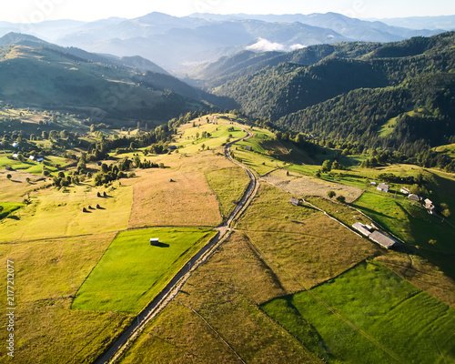 Fotografía Aerial view of picturesque rural landscape at sunrise, with rolling hills and lush green fields