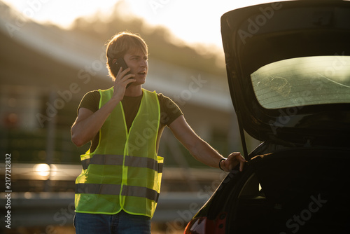 Obraz na plátne Man phoning for roadside assistance after car breakdown