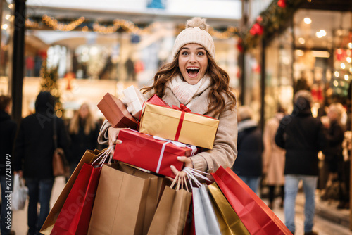 Happy Excited Woman Holding Many Christmas Gifts and Shopping Bags in Mall