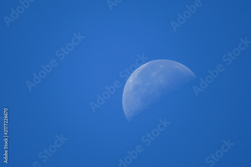 Obraz na płótnie Daytime half moon in clear blue sky
