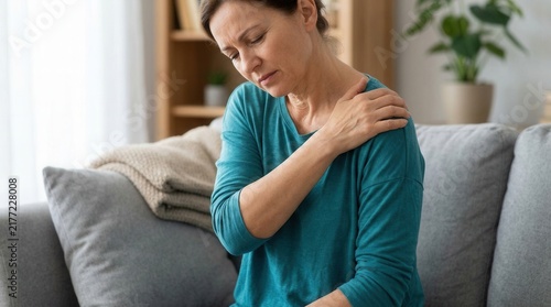 Mature Woman Experiencing Shoulder Pain While Relaxing At Home