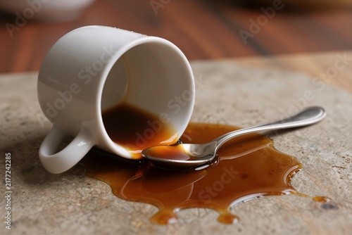 Spilled Coffee Cup and Spoon on Wooden Table