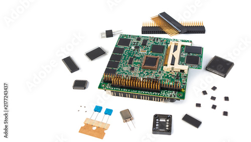 Electronic components are spread out on a white table with a circuit board at the center and various chips surrounding it