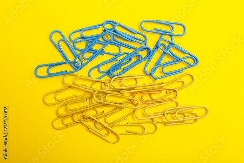 Blue and Yellow Paperclips on Yellow Background