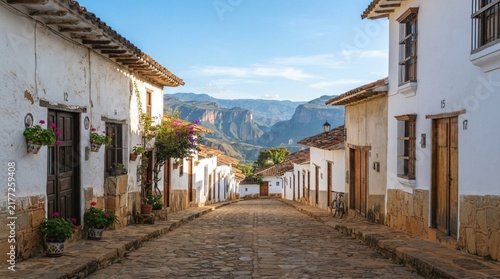 Picturesque cobblestone street lined with traditional white colonial houses