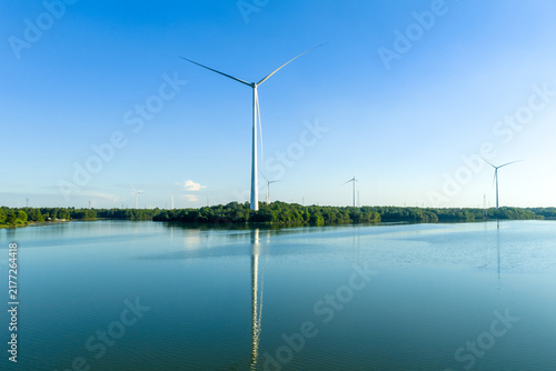 Large wind turbine standing on the lake surface
