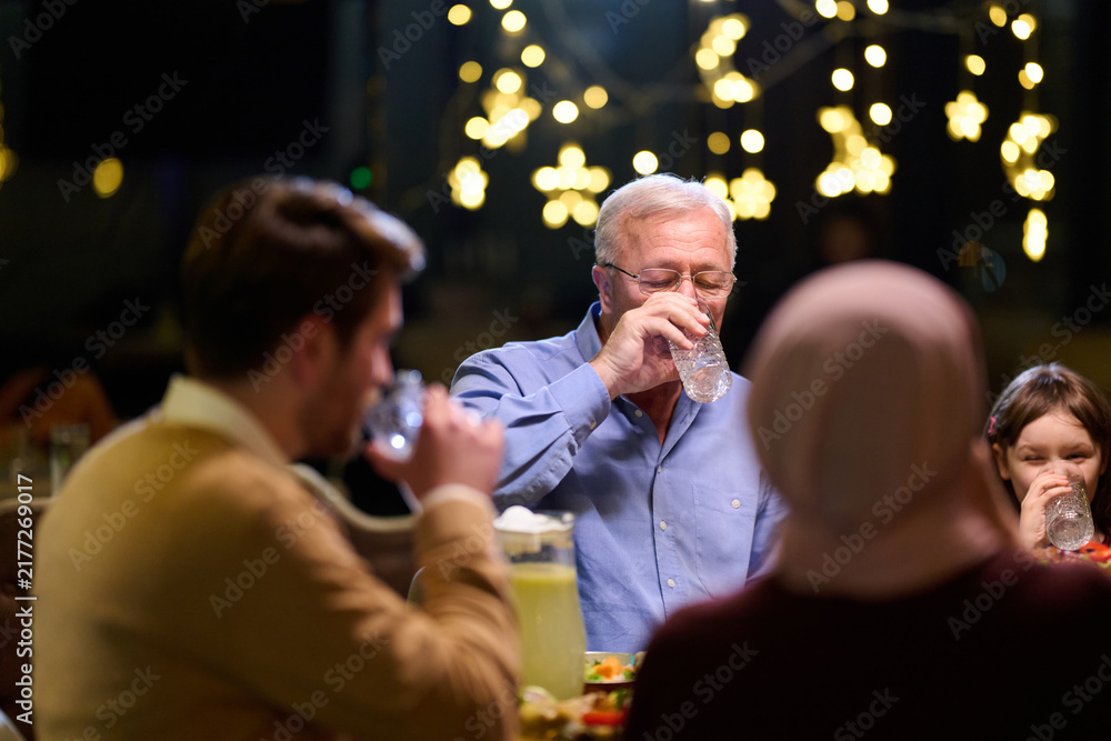 Naklejka premium Multigenerational Family Dinner Celebration Around a Table With Warm Lights and Smiles