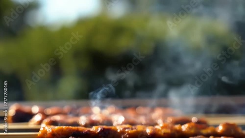 Grilled hot dogs with smoke rising from the barbecue grill, perfect for outdoor events and summer cookouts