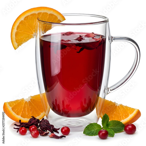 Glass mug of hot red fruit tea with orange slices and berries