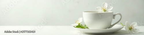 Delicate white blossoms & green leaves adorn a porcelain teacup on pristine white , nature, tea party