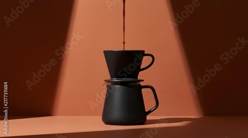 Minimalist black pour over coffee maker on orange.