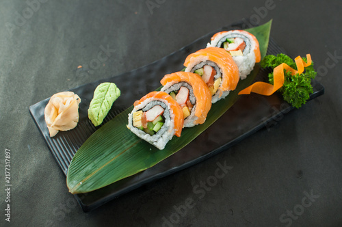 Konstfotografi Delicious salmon sushi rolls served with wasabi and ginger on a black plate