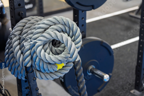 Konstfotografi battle ropes and barbell equipment placed inside modern gym