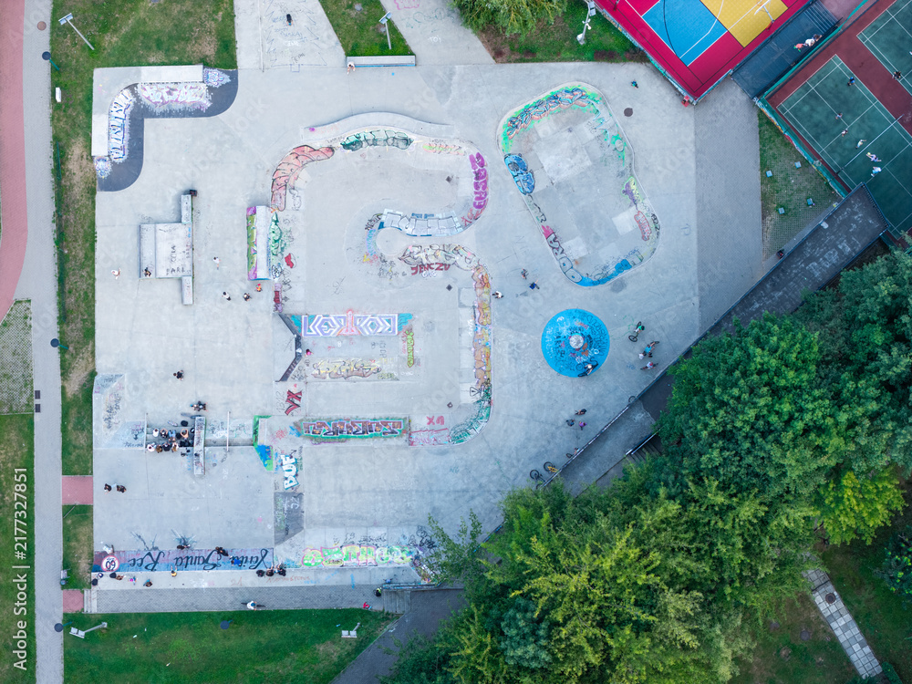 Fototapeta premium Urban skate park with colorful graffiti designs, aerial view of concrete sports area