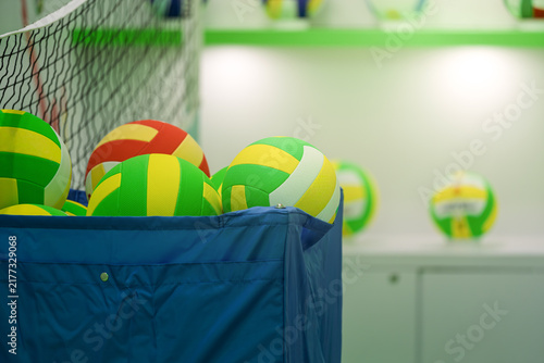 multiple volleyball equipments placed inside storage baskets at indoor volleyball gym
