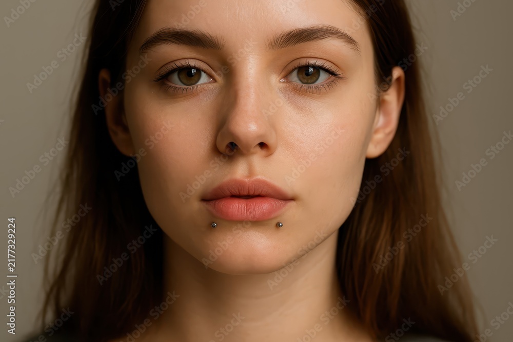 Fototapeta premium Young woman with angel bites piercing portrait
