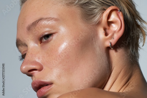 Close-up of woman's ear with multiple silver piercings