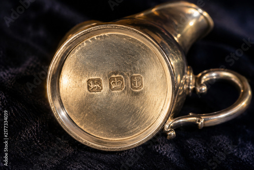 Antique silver cream jug with hallmark stamps on dark velvet, craftsmanship and heritage concept