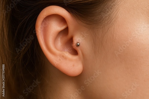 Close-up of woman's ear with silver tragus piercing