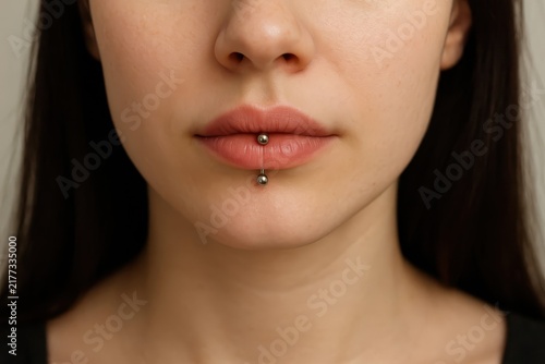 Young woman with labret piercing in neutral light