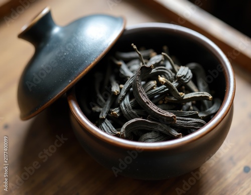 A bowl of black tea sitting on a wooden table, perfect for a cozy moment or a relaxing break