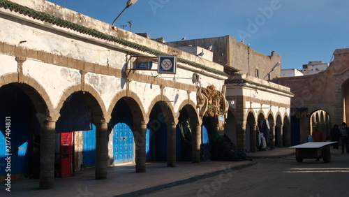Konstfotografi Arched supports for a patio in front of blue doors for individual shops in the m