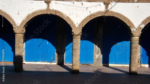 Foto Arched supports for a patio in front of blue doors for individual shops in the m