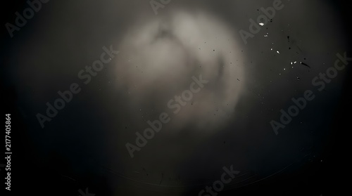 Abstract background featuring a dark and moody smoked celluloid surface with soft glowing light and subtle vintage texture