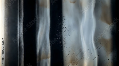 Abstract background featuring a dark smoked celluloid surface with subtle light reflections and artistic vintage film grain texture patterns