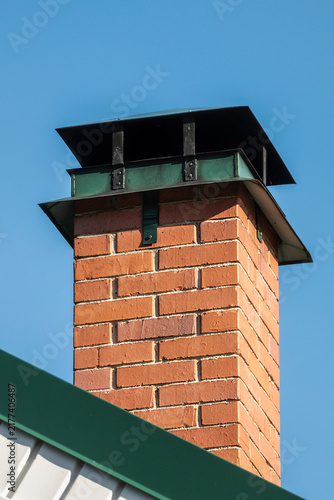 A brick chimney on the roof on a summer day