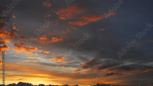 A dramatic sky at dusk, with colourful clouds against a dark backdrop.