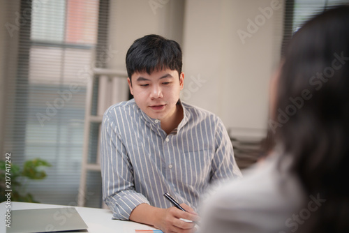 Obraz na plátne Young Asian man actively engaging in a professional interview or business meeting