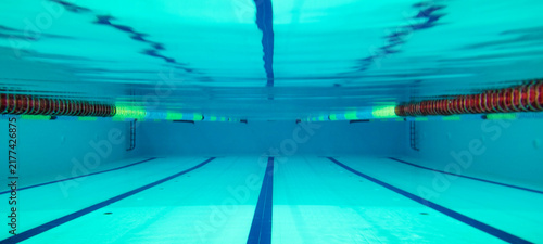 Bild auf Leinwand Underwater shot of a 25m swimming pool with the bottom lanes reflecting on the s