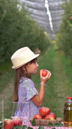 Blue-Eyed Girl Eating a Fresh Apple and Sharing Her Reaction. Young girl enjoys freshly picked fruit as her farmer father smiles and gives a thumbs-up.