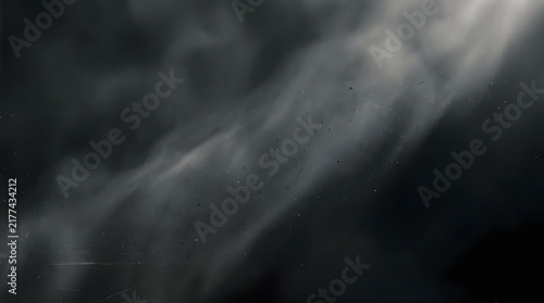 Abstract dark background featuring a deep charcoal grain atmosphere with soft light rays creating a moody and mysterious artistic texture