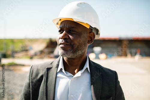Senior engineer wearing hard hat at outdoor construction site