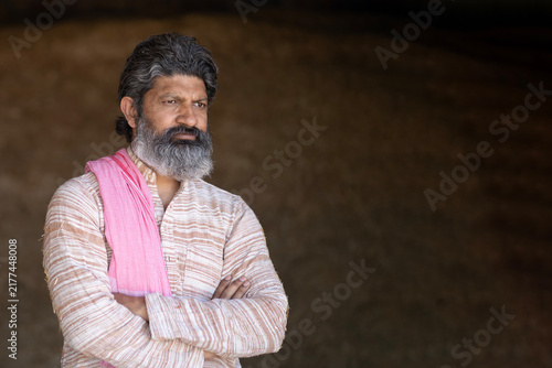 Bild auf Leinwand Indian sad poor old rural farmer man sitting in crop farmland and lost deeply discouraged