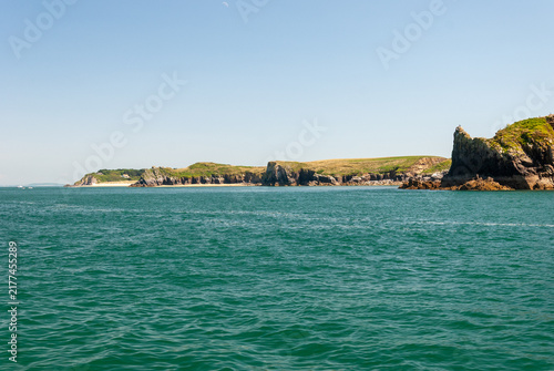 Obraz na płótnie Sunny summer day at Tenby Beach Wales – golden sand, turquoise sea, people swimm