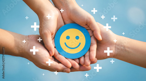 Hands United Holding Smiley Emblem Representing Health and Wellbeing.