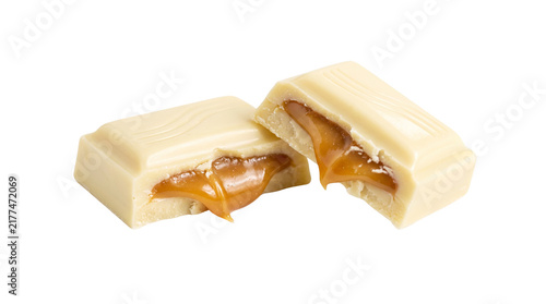 Konstfotografi White Chocolate Bar Pieces Filled with Flowing Caramel Sauce Isolated on Black B
