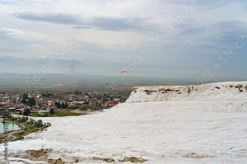 Red paraglider over the white travertine terraces of Pamukkale with a view of the valley, paragliding adventure, Denizli Province, Aegean Region, Türkiye