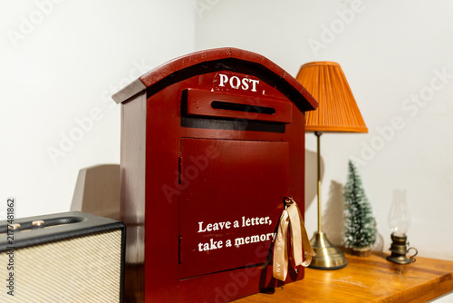 Bild auf Leinwand Red wooden postbox in a cafe interior with decorative lamp
