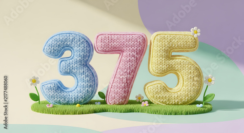 Chunky knitted numbers 375 on a green grass patch, in pastel blue, pink, and yellow with flowers.