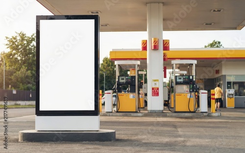 Blank vertical billboard sign at a yellow gas station