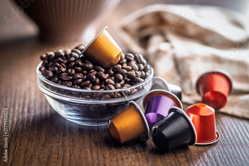 Glass Bowl Of Coffee Beans With Colorful Espresso Capsules On Wooden Table For Morning Coffee