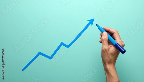 Blue Marker Drawing a Rising Graph in Hand on Soft Mint Background, Business Growth, Financial Success and Upward Trend Concept