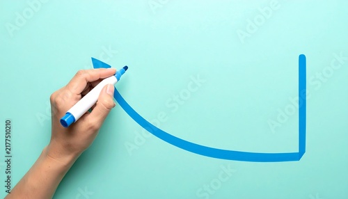 Blue Marker Drawing a Rising Graph in Hand on Soft Mint Background, Business Growth, Financial Success and Upward Trend Concept